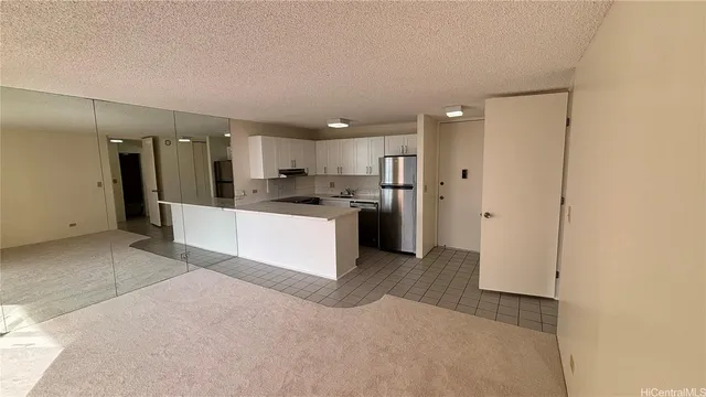 a view of a kitchen with a sink and dishwasher a refrigerator with white cabinets