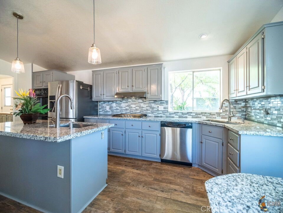 4898 Forrester Road Brawley, CA 92227 - Photo 6 of 10 a kitchen with stainless steel appliances granite countertop a sink a stove a refrigerator cabinets and a window