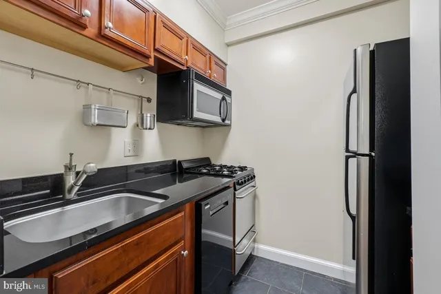 a kitchen with stainless steel appliances granite countertop a sink stove and refrigerator
