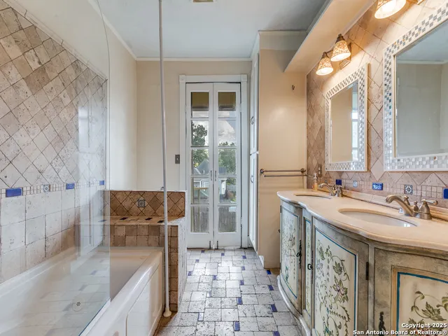 a spacious bathroom with a tub sink and mirror