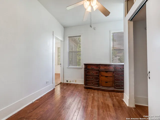 an empty room with wooden floor closet and chandelier