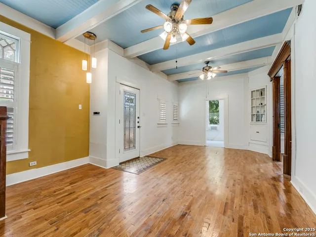a view of empty room with wooden floor