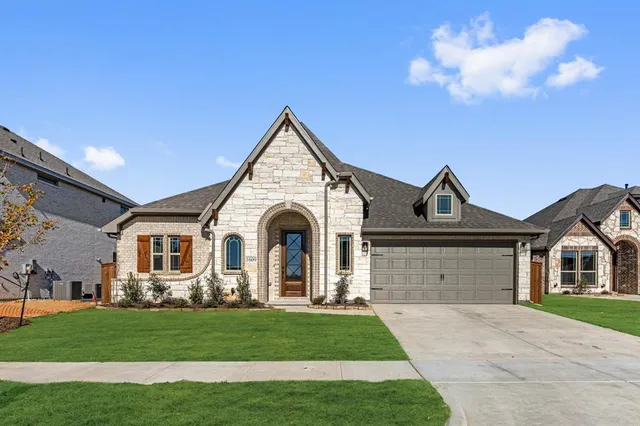 a front view of a house with a garden and yard