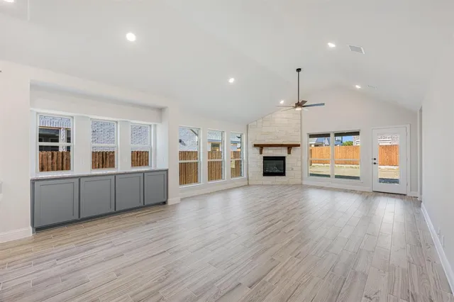 an empty room with wooden floor and fireplace