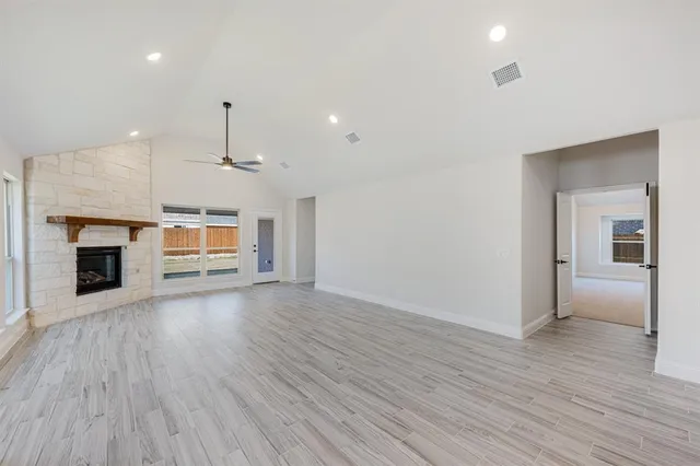 a view of a room with wooden floor fireplace and window