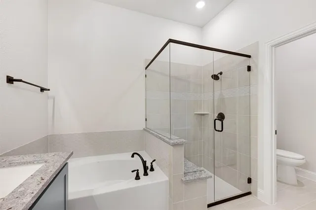 a bathroom with a granite countertop sink a toilet and shower