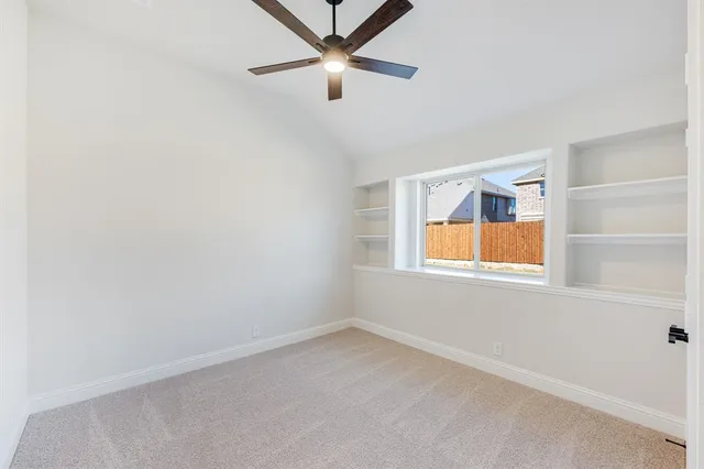 an empty room with window and ceiling fan