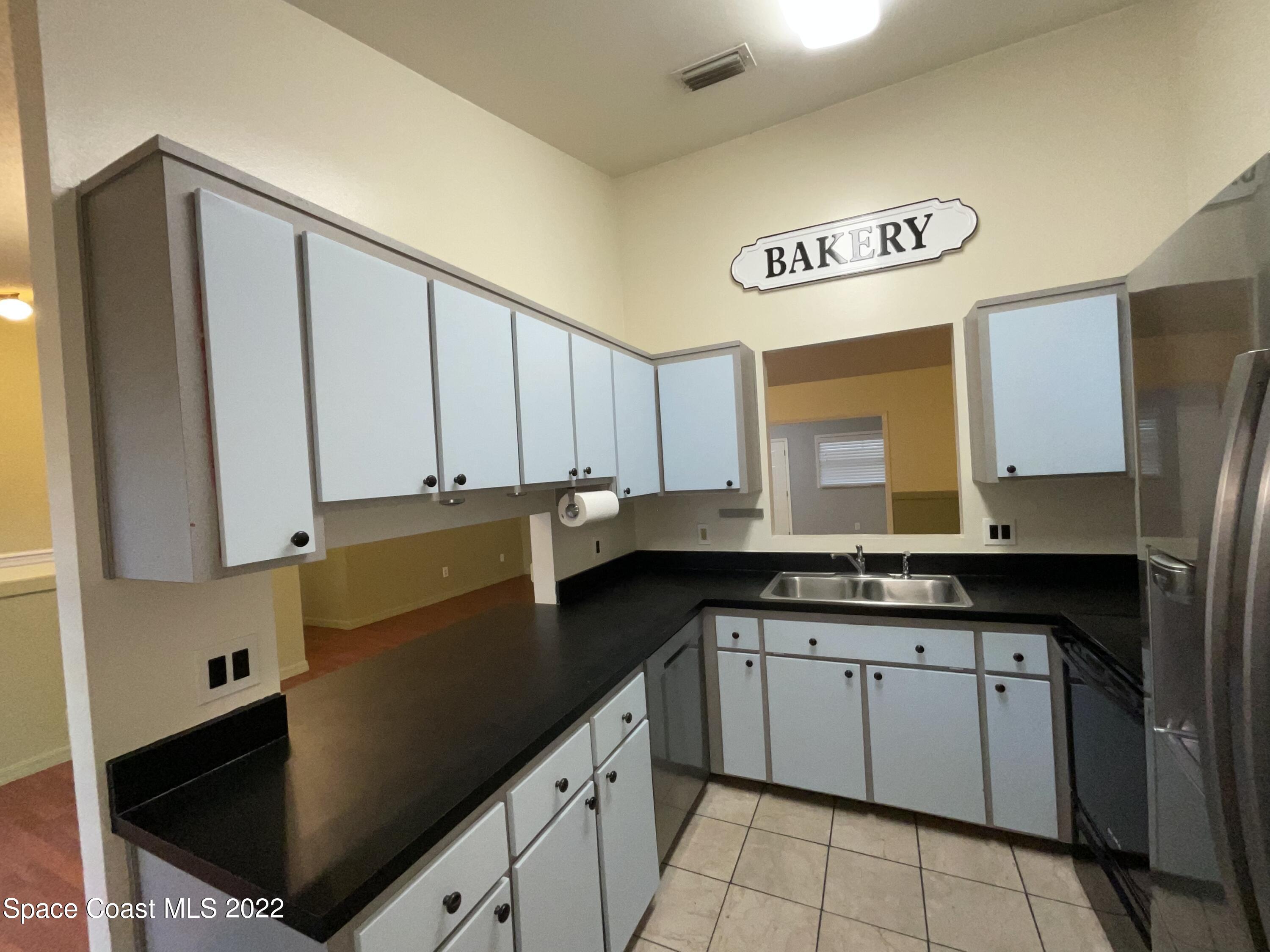 4844 Bridge Road Cocoa, FL 32927 - Photo 13 of 22 a kitchen with granite countertop a sink a stove and refrigerator