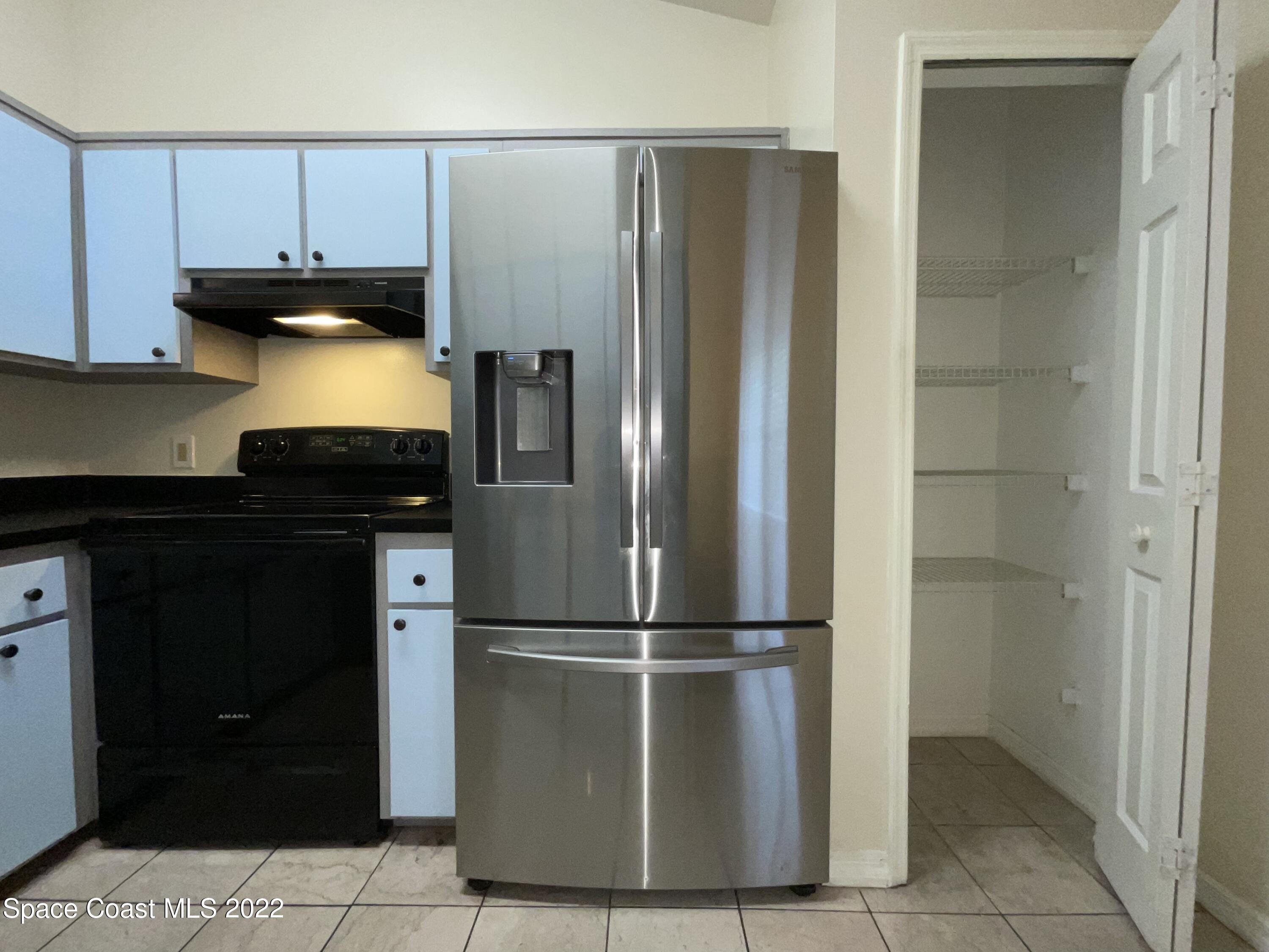 4844 Bridge Road Cocoa, FL 32927 - Photo 14 of 22 a kitchen with a refrigerator and a cabinets