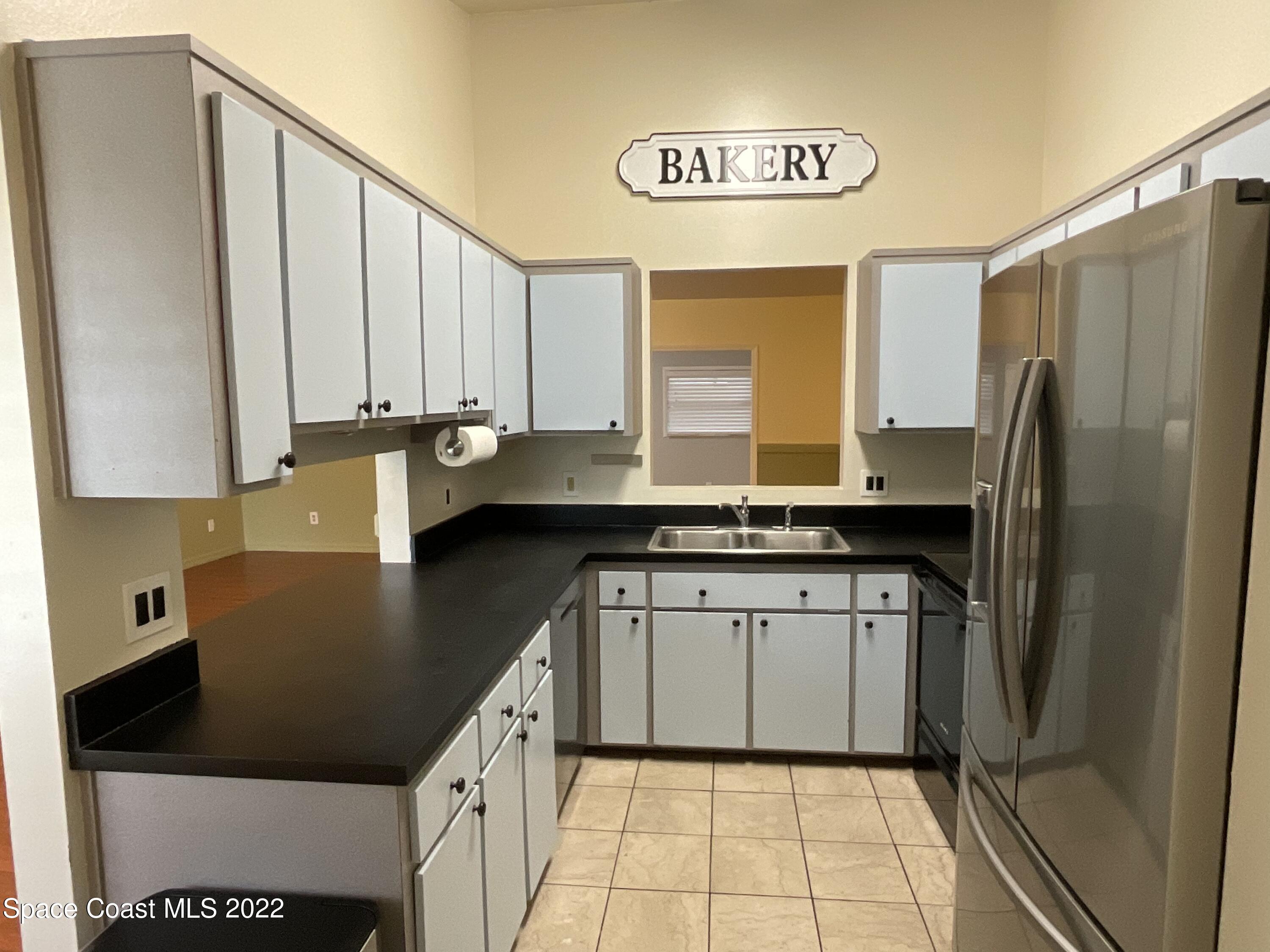 4844 Bridge Road Cocoa, FL 32927 - Photo 18 of 22 a kitchen with a sink a refrigerator and cabinets