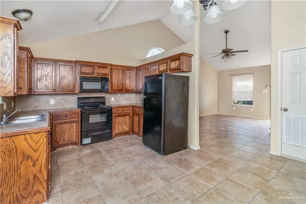 a kitchen with granite countertop a refrigerator and a stove top oven