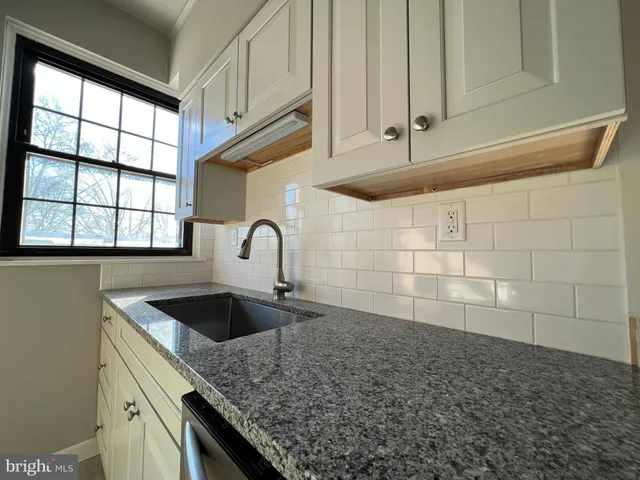 a kitchen with granite countertop a sink and cabinets