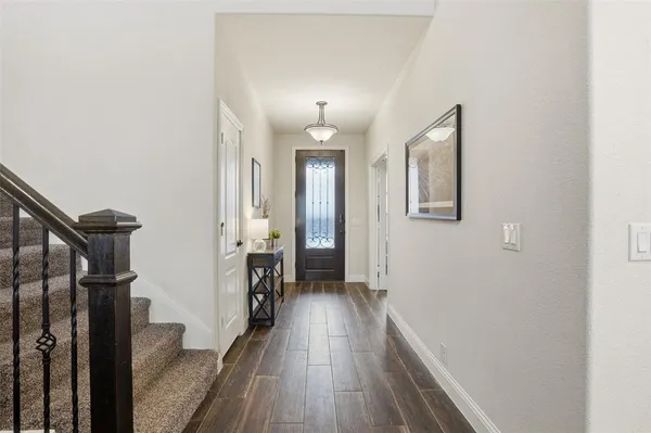 a view of a hallway with wooden floor and staircase