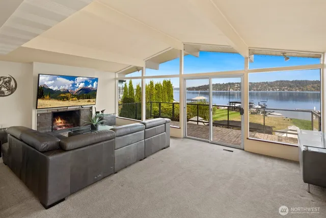 a living room with furniture a flat screen tv and floor to ceiling window