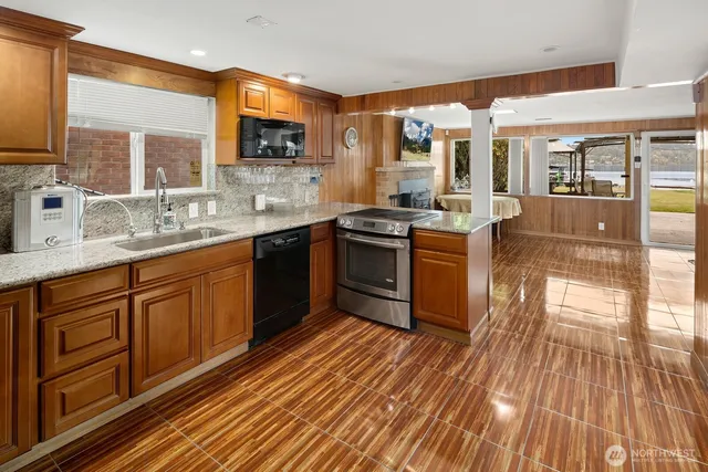 a kitchen with stainless steel appliances granite countertop wooden floors and sink