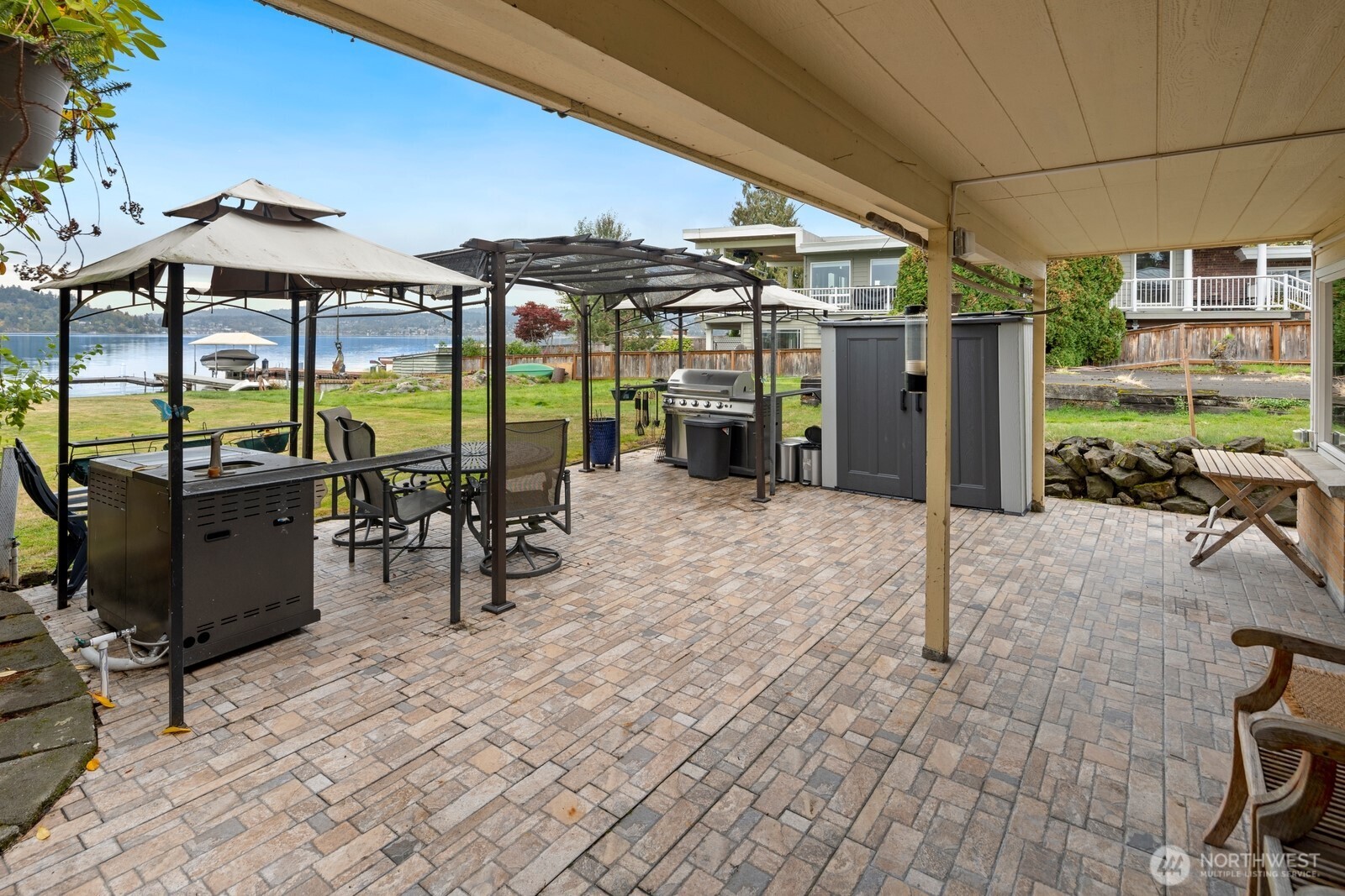 10008 Rainier Avenue South Seattle, WA 98178 - Photo 26 of 40 a view of a patio with a table and chairs under an umbrella with a barbeque