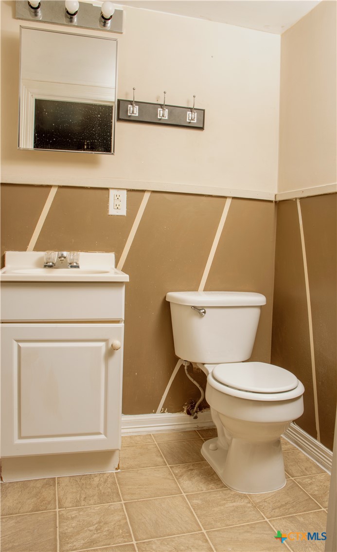 1407 South 7th Street Temple, TX 76504 - Photo 34 of 36 a white toilet sitting next to a bathroom sink