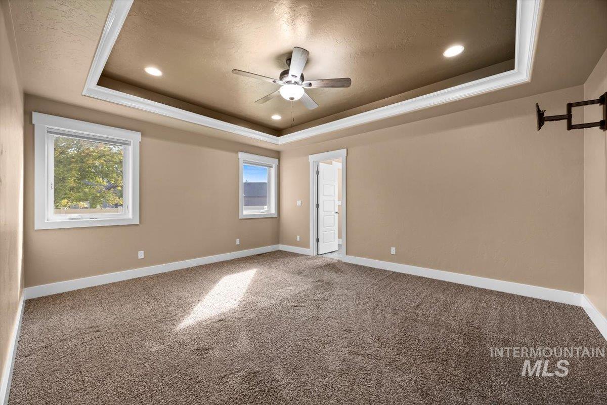13557 Signorello Street Caldwell, ID 83607 - Photo 11 of 30 Empty room with carpet, a raised ceiling, a textured ceiling, recessed lighting, and a ceiling fan