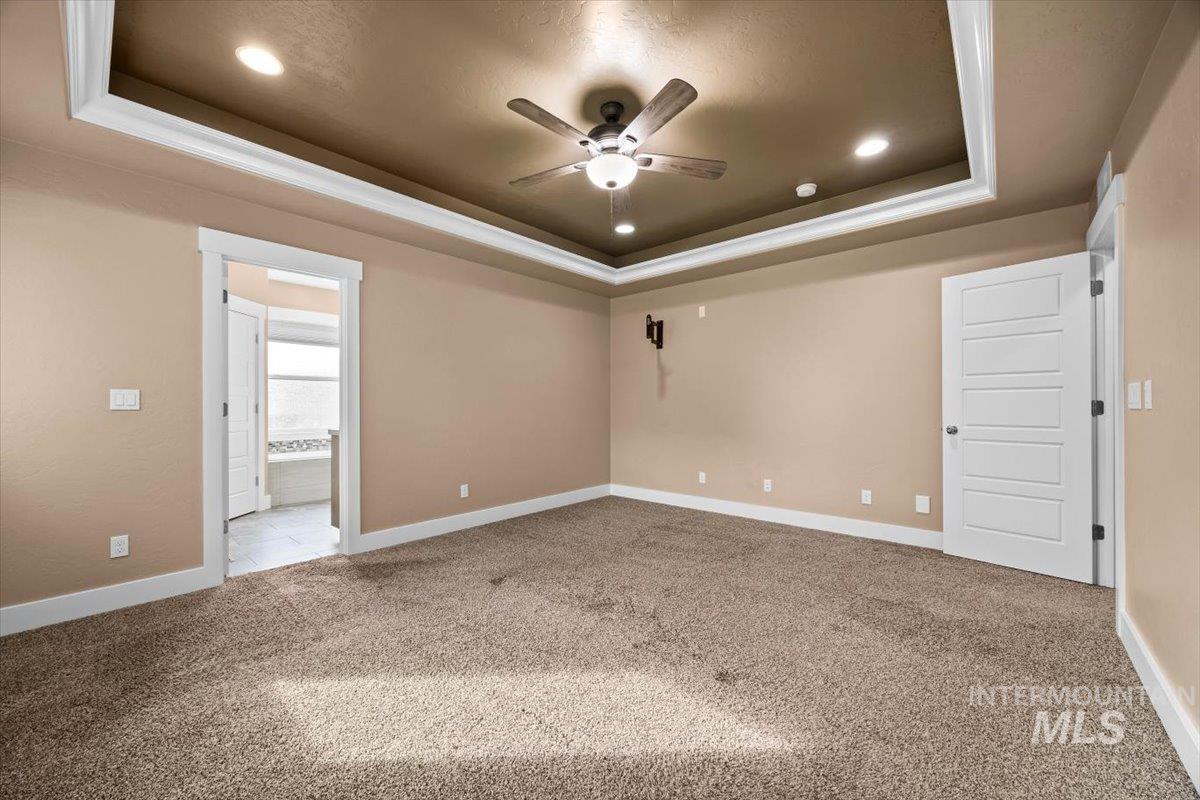 13557 Signorello Street Caldwell, ID 83607 - Photo 12 of 30 Unfurnished room with a tray ceiling, light carpet, ceiling fan, and recessed lighting