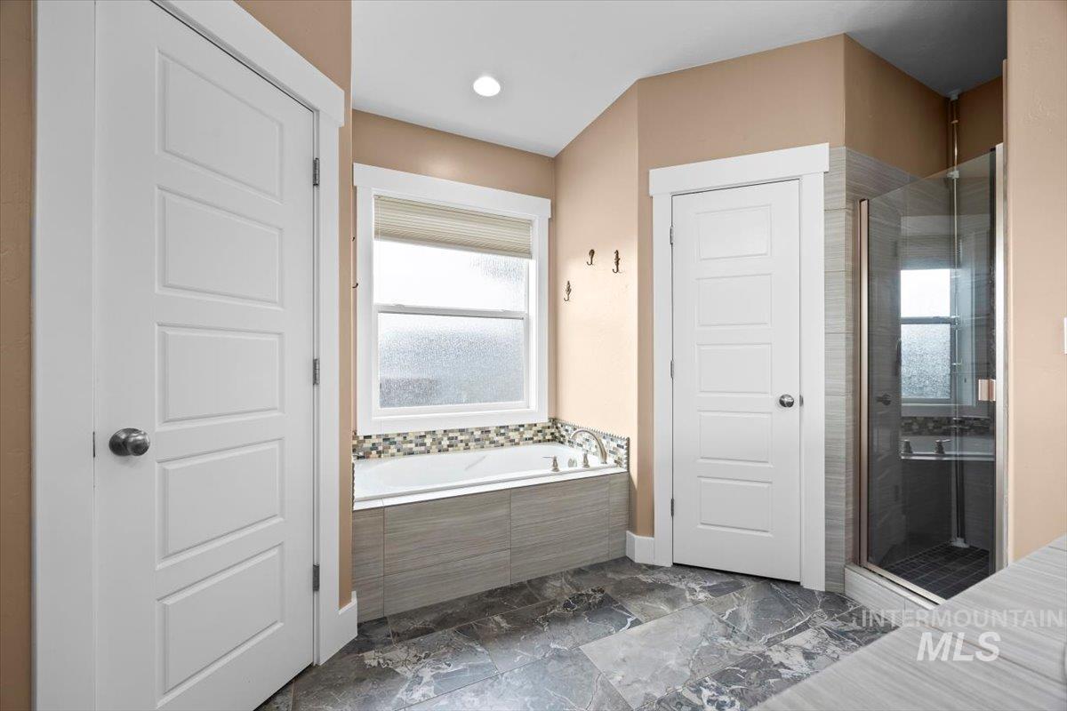 13557 Signorello Street Caldwell, ID 83607 - Photo 15 of 30 Full bathroom featuring a stall shower, a garden tub, and recessed lighting