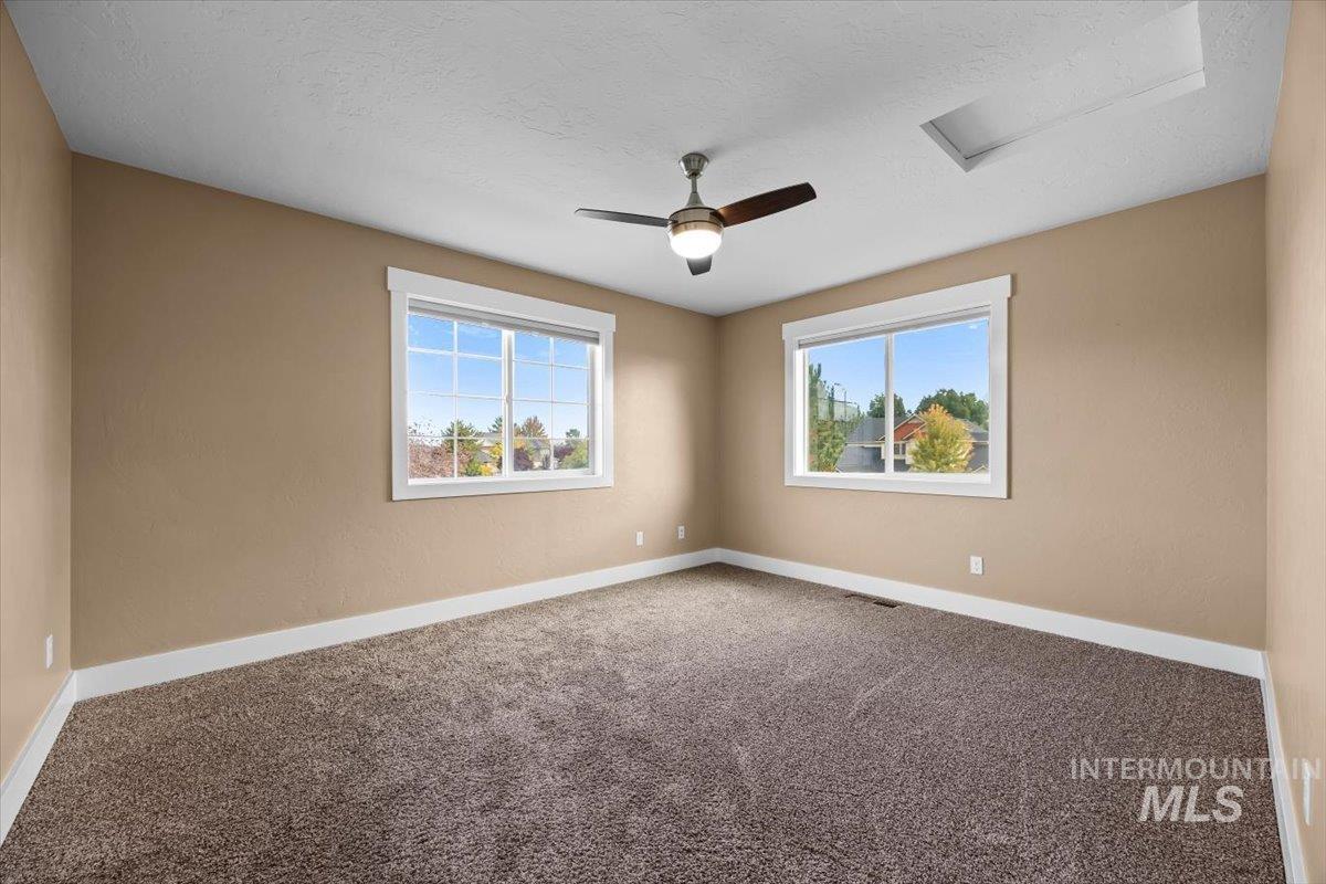 13557 Signorello Street Caldwell, ID 83607 - Photo 18 of 30 Spare room featuring carpet floors, healthy amount of natural light, a textured ceiling, and ceiling fan
