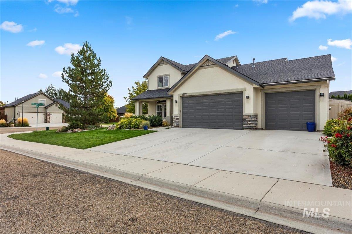 13557 Signorello Street Caldwell, ID 83607 - Photo 2 of 30 View of front of home featuring stucco siding, driveway, a garage, stone siding, and a front yard