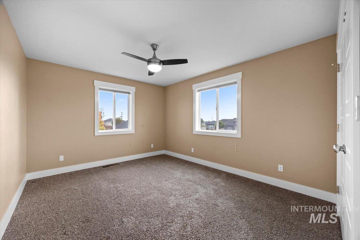 13557 Signorello Street Caldwell, ID 83607 - Photo 22 of 30 Carpeted empty room with baseboards and a ceiling fan