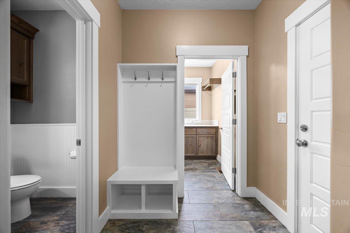 13557 Signorello Street Caldwell, ID 83607 - Photo 25 of 30 Mudroom featuring dark stone finish flooring and a wainscoted wall