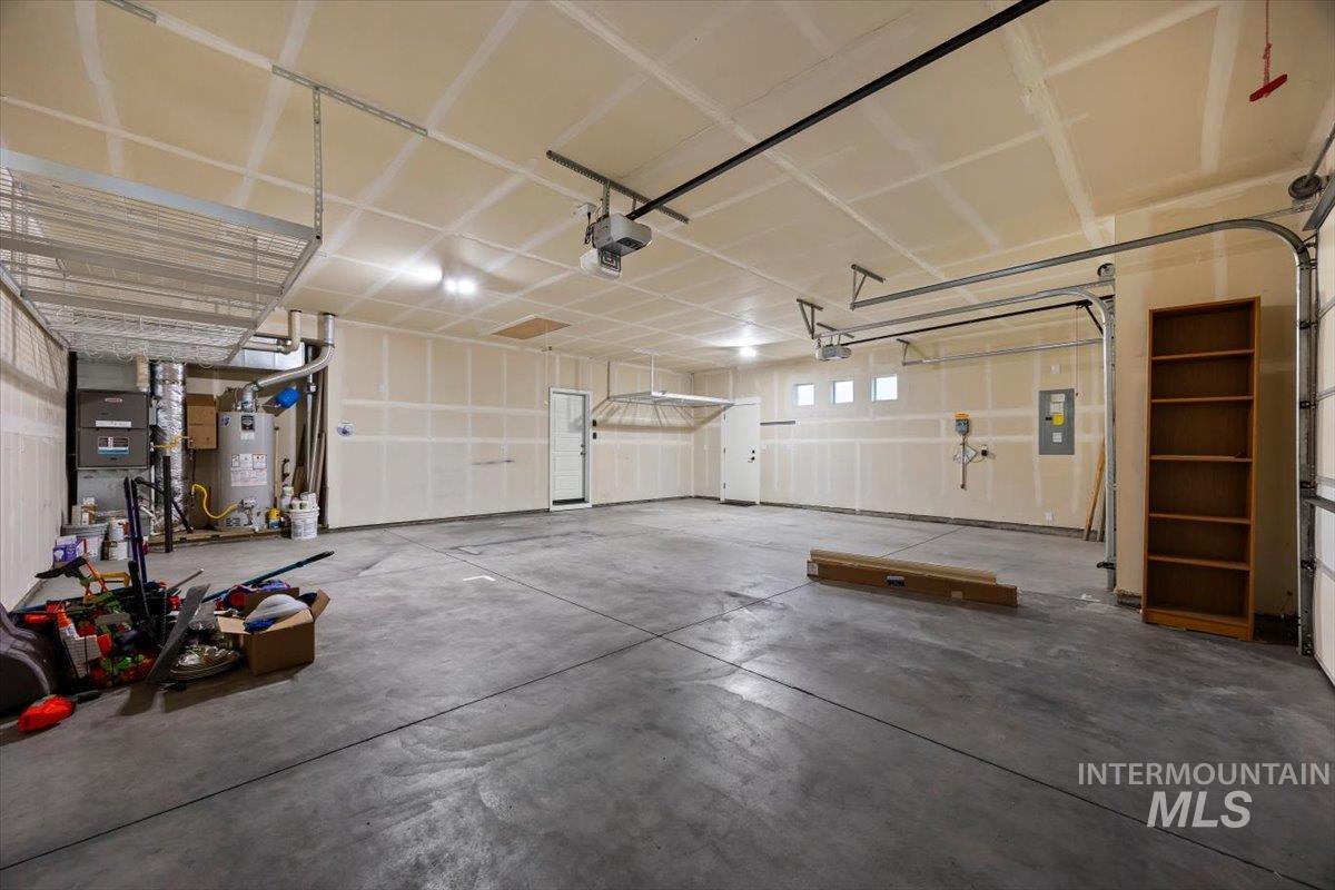 13557 Signorello Street Caldwell, ID 83607 - Photo 27 of 30 Garage featuring gas water heater, electric panel, heating unit, and a garage door opener