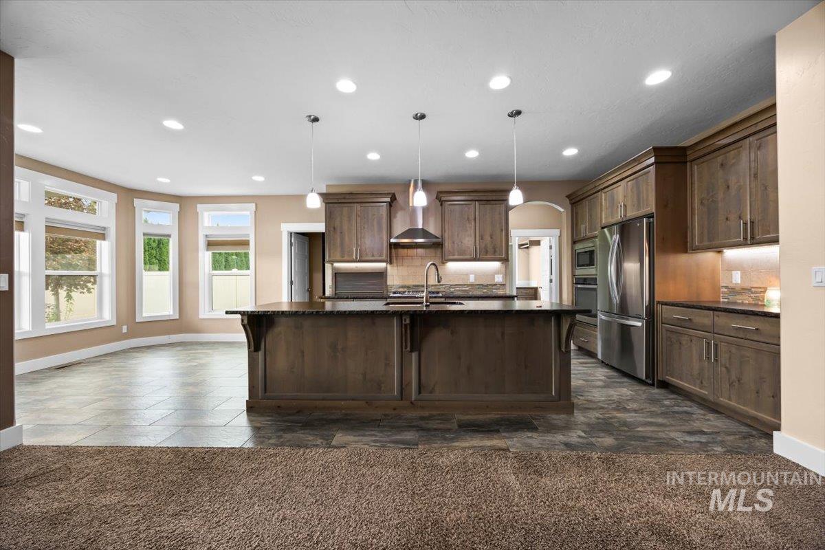 13557 Signorello Street Caldwell, ID 83607 - Photo 6 of 30 Kitchen with decorative backsplash, recessed lighting, pendant lighting, stainless steel appliances, and an island with sink