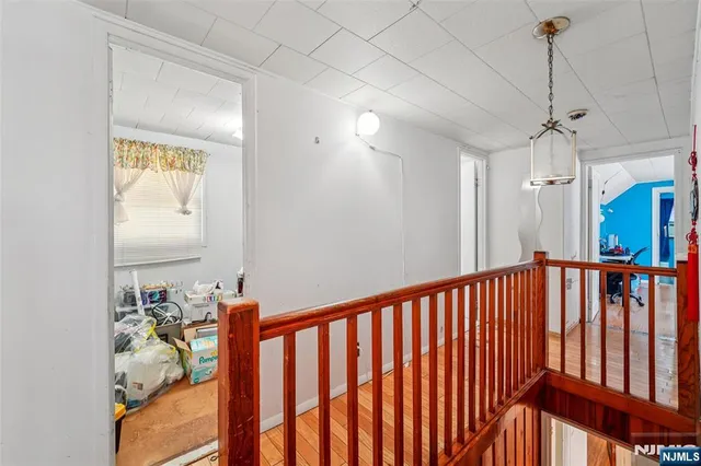 a view of a hallway with a dining table chairs and chandelier