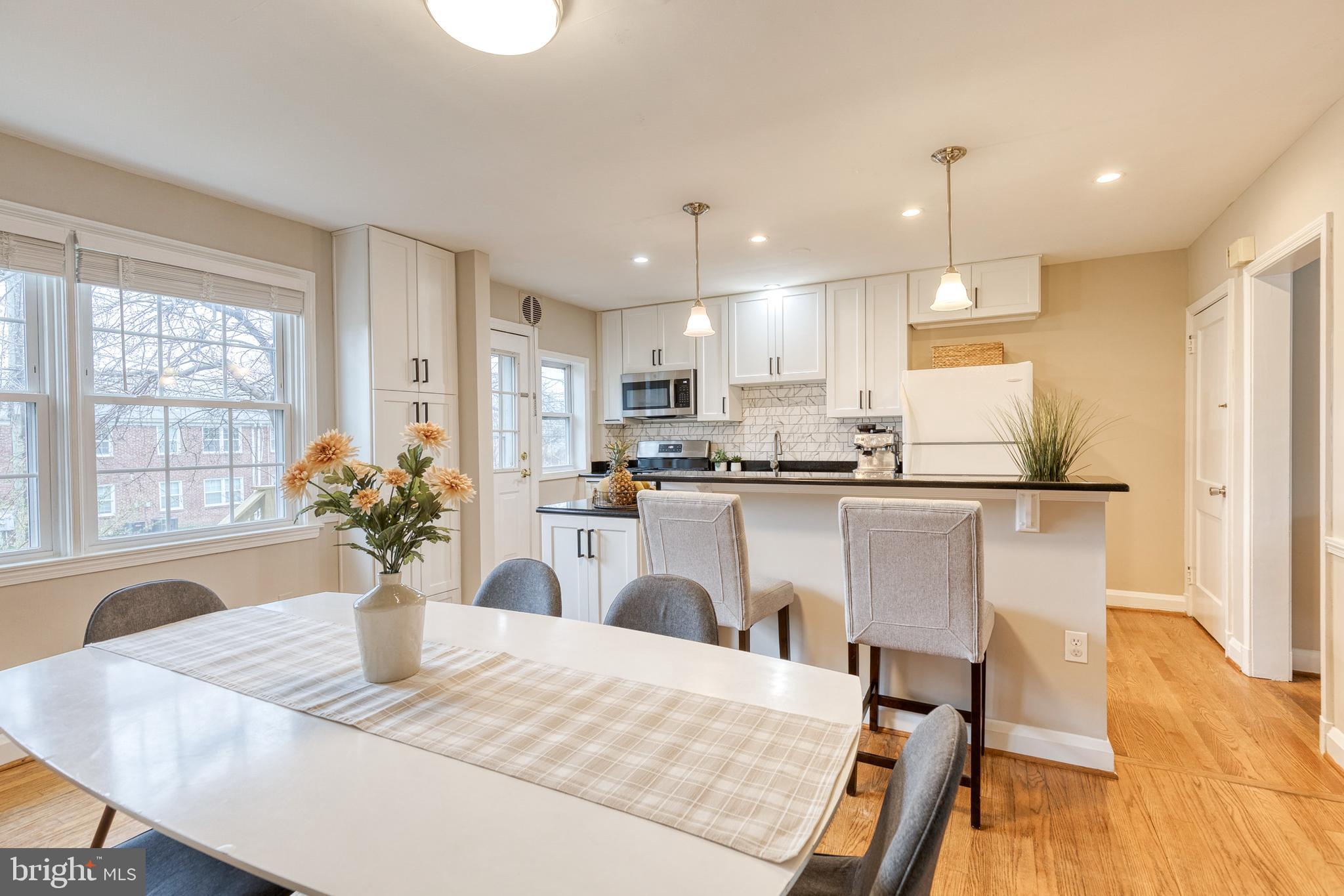 31 Regester Avenue Baltimore, MD 21212 - Photo 12 of 38 a kitchen with stainless steel appliances granite countertop sink refrigerator dining table and chairs