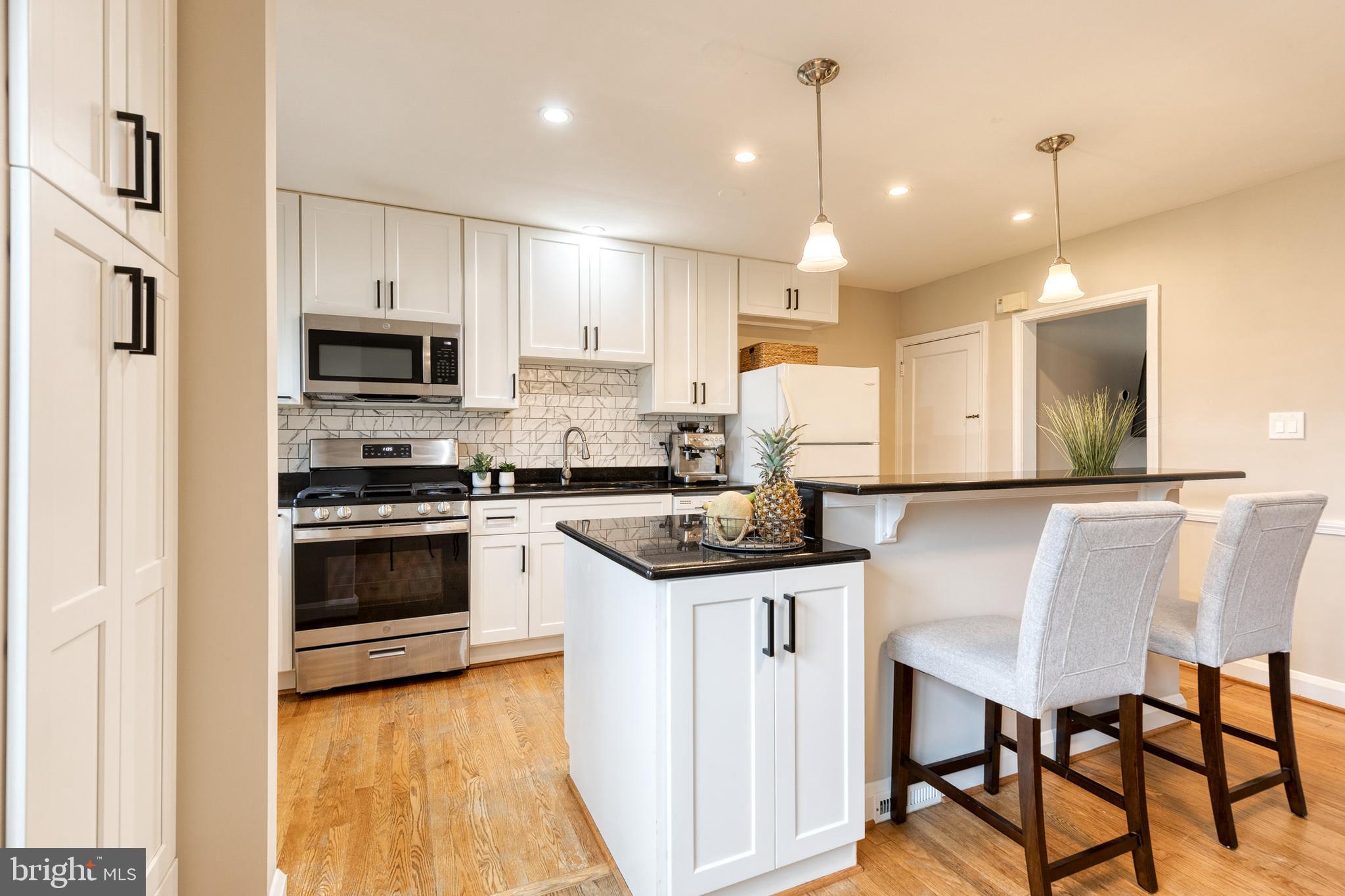 31 Regester Avenue Baltimore, MD 21212 - Photo 16 of 38 a kitchen with granite countertop a stove a sink and a refrigerator