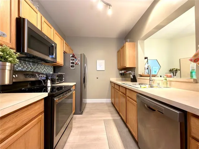 a kitchen with stainless steel appliances granite countertop a sink and a stove