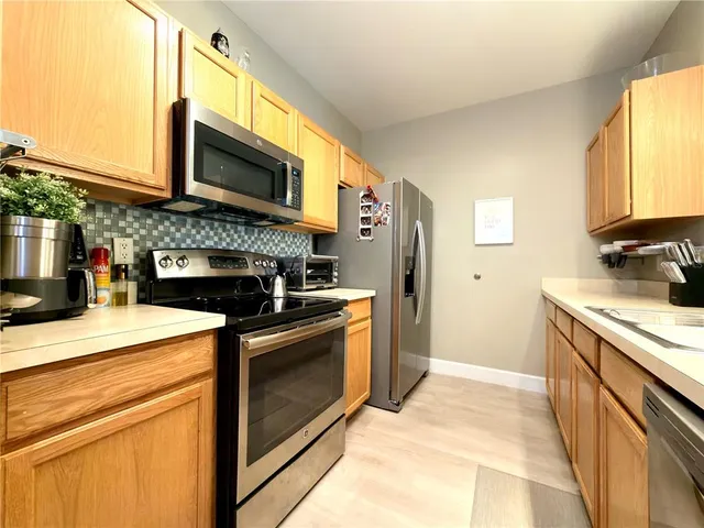 a kitchen with stainless steel appliances granite countertop a stove microwave and sink