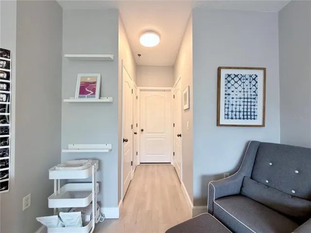 a view of hallway with furniture and wooden floor