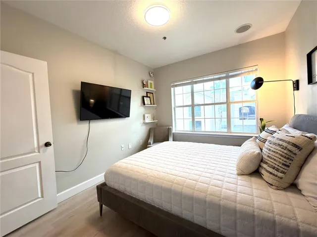 a bedroom with a bed tv and window