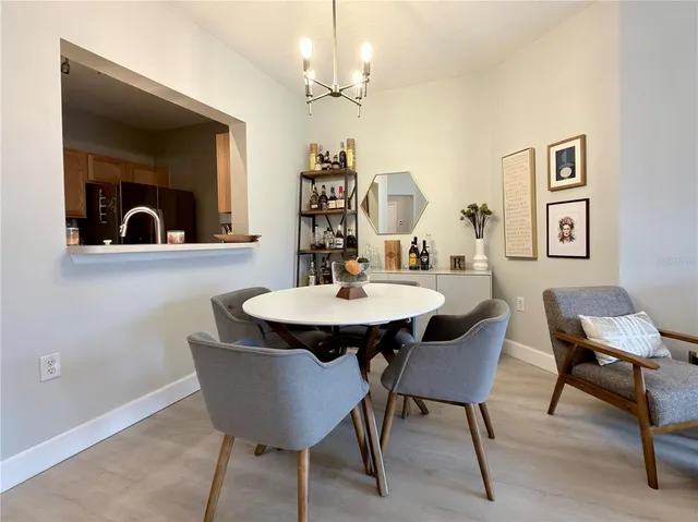 a view of a dining room with furniture and a chandelier fan