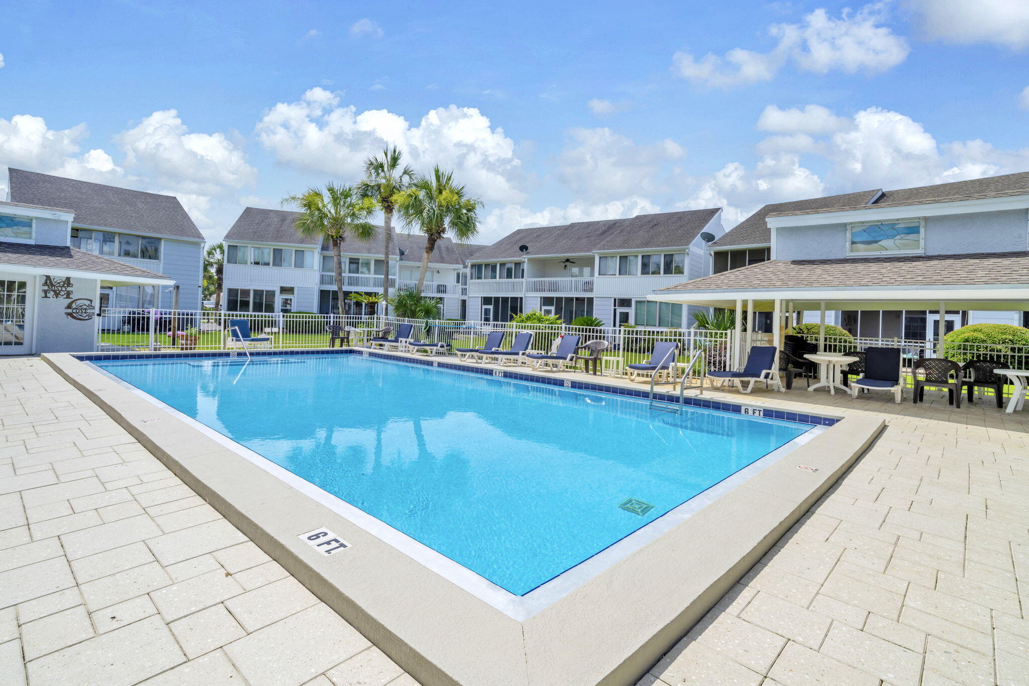 288 Ellis Road, Unit 114 Miramar Beach, FL 32550 - Photo 27 of 30 a view of a building with a swimming pool and lawn chairs