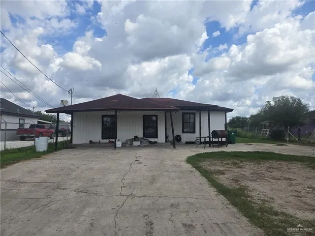 a view of a house with a yard and sitting area