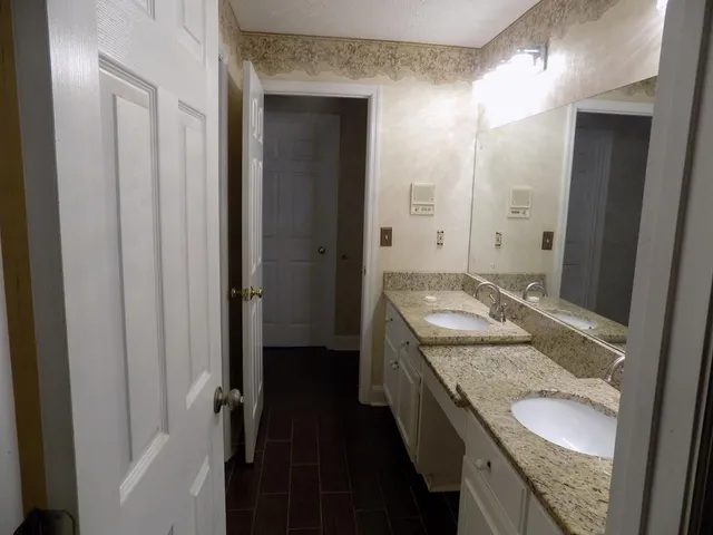 a bathroom with a granite countertop sink and a mirror