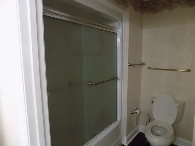 a bathroom with a toilet and a shower