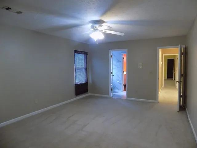 a view of a livingroom with a ceiling fan and window