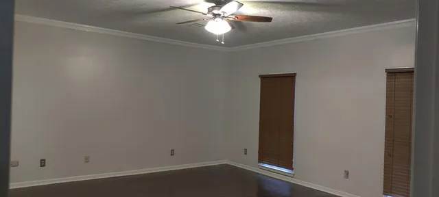 an empty room with a chandelier fan