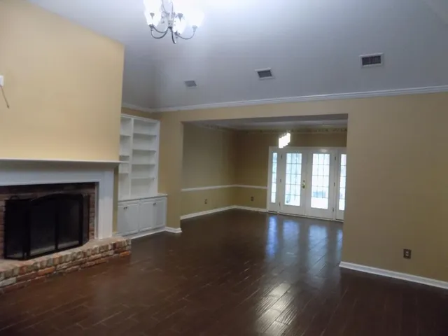 an empty room with wooden floor and fireplace