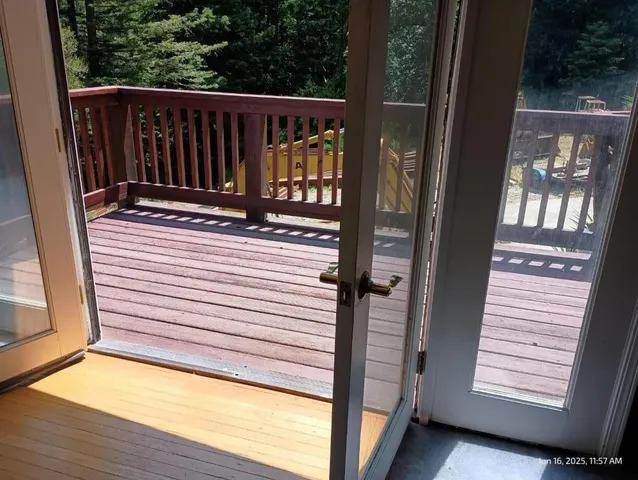 a view of a balcony with floor to ceiling window and wooden floor