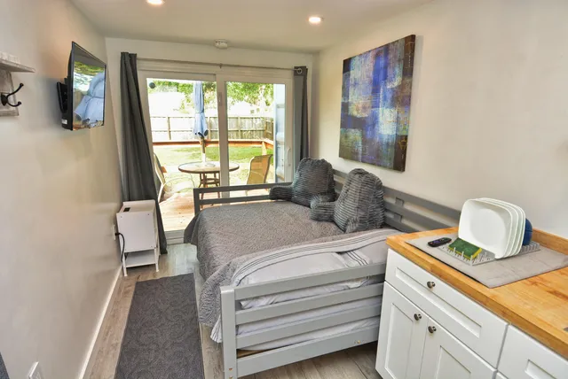 a bedroom with a bed and large windows