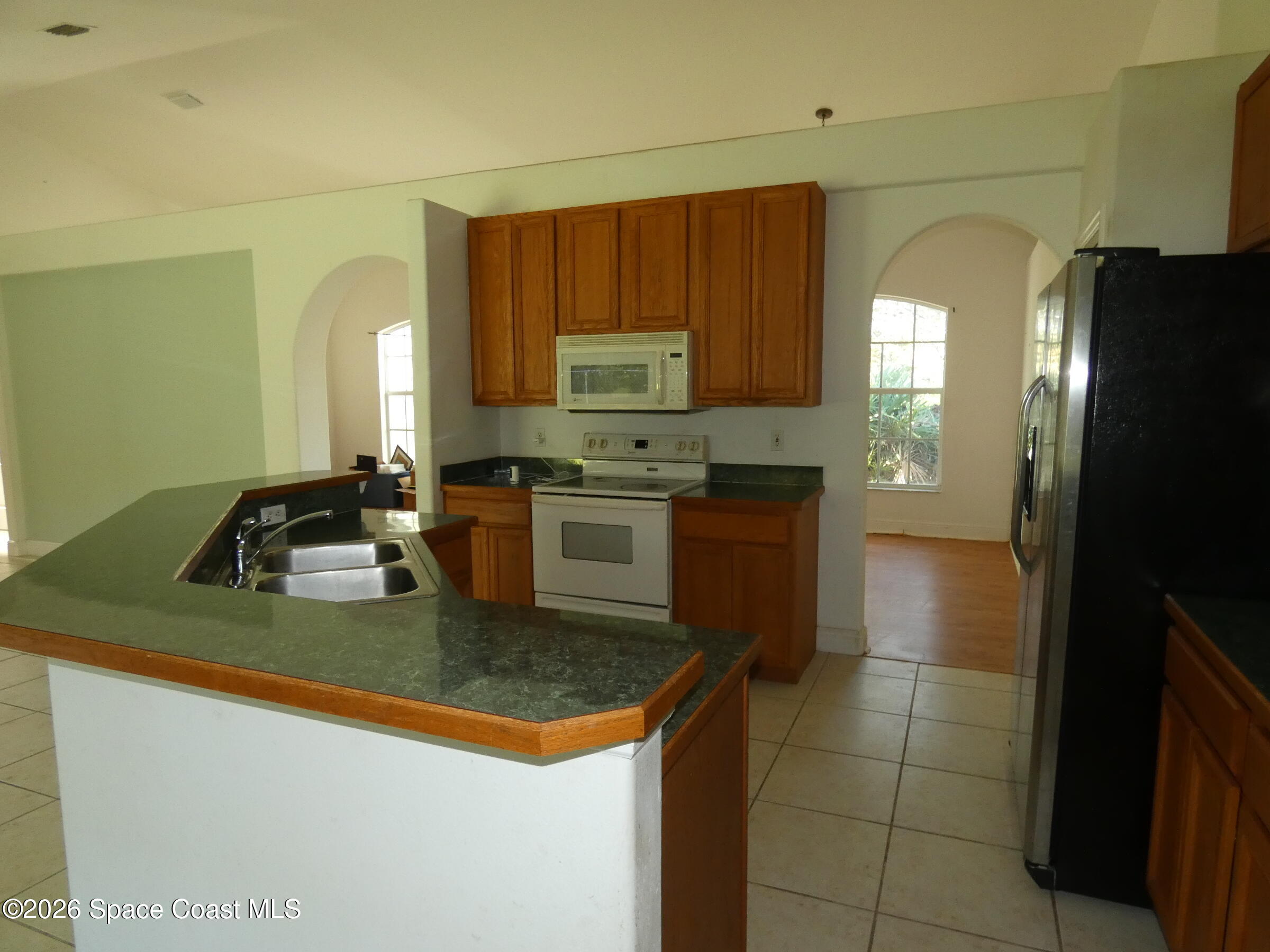 3195 Legendary Lane Melbourne, FL 32935 - Photo 9 of 25 a kitchen with a sink a stove and cabinets