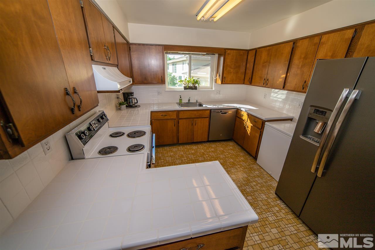 3540 Yosemite Place Reno, NV 89503 - Photo 4 of 23 a kitchen with stainless steel appliances granite countertop a sink a stove a microwave a refrigerator and cabinets