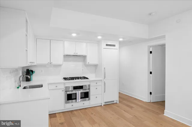 a kitchen with granite countertop white cabinets and white appliances
